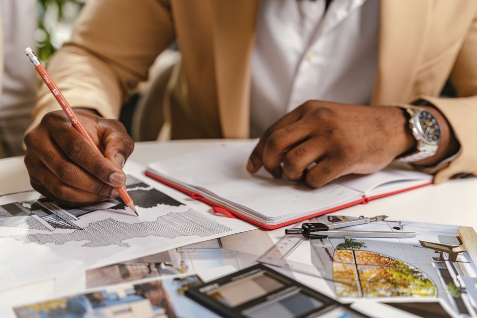Arquitecta trazando un plano sobre una mesa de dibujo iluminada